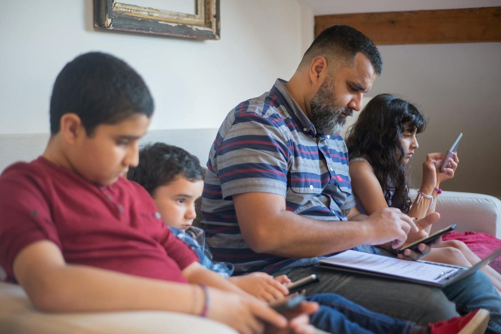 Parents and children using digital devices together at home