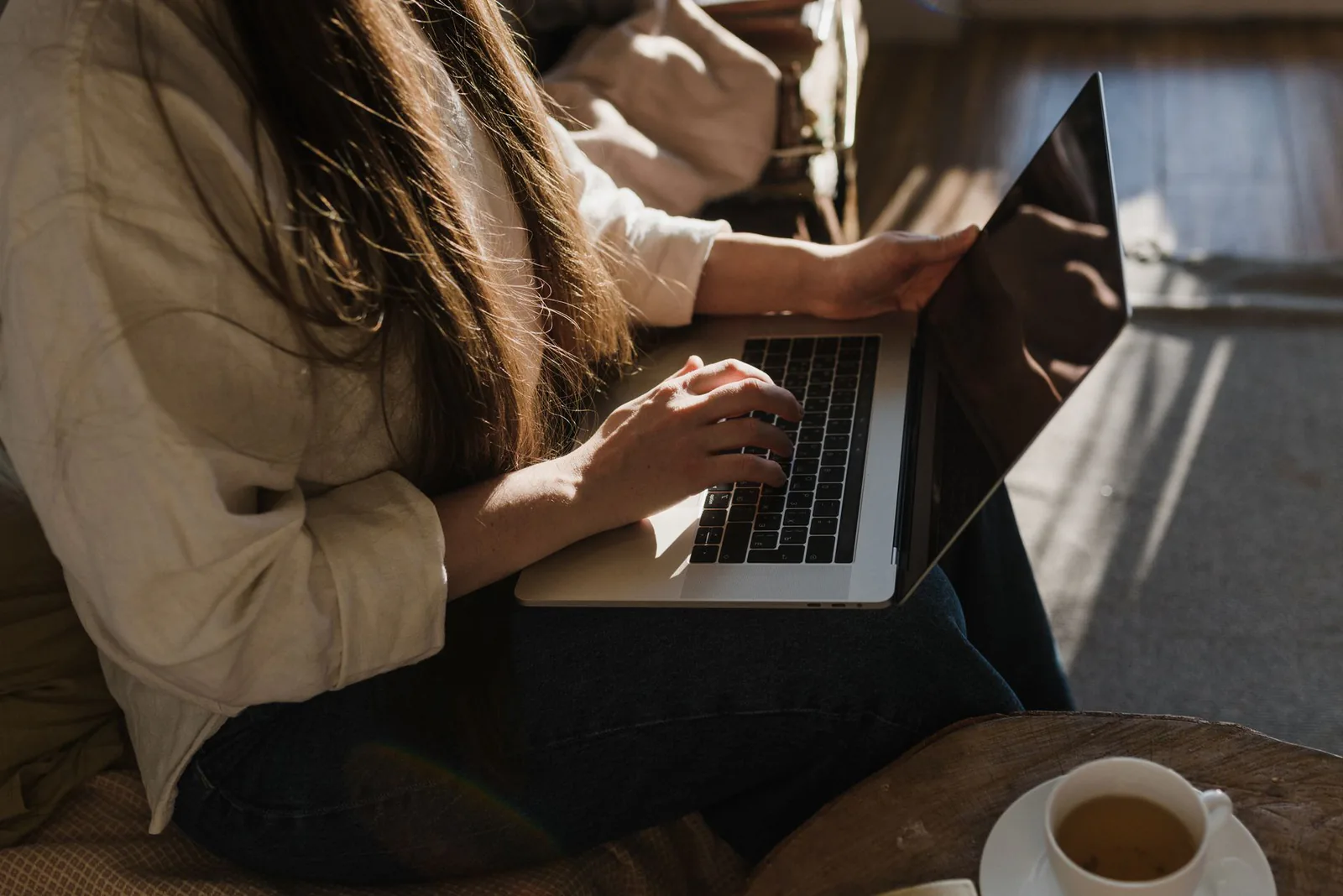 Osoba pisząca wiadomość na laptopie w ciepłym domowym świetle